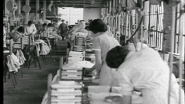 20世纪20年代PAN工人在服装厂/新闻片中折叠、包装、熨烫衬衫视频下载