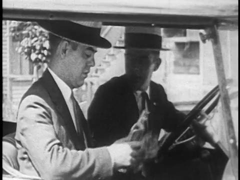 1925年，两个戴着草帽的男人偷偷地从汽车/新闻胶卷里的烧瓶里喝东西视频下载
