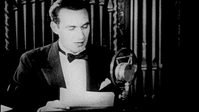 1927年，一名穿着燕尾服的男子在广播演播室/新闻短片中对着麦克风讲话视频下载