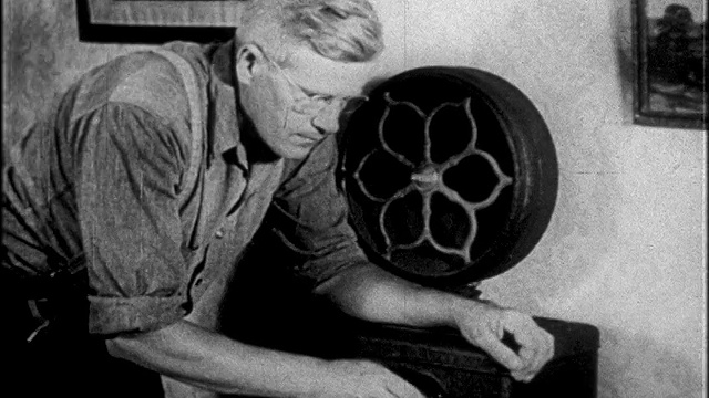 1927年，一名戴眼镜的男子站在早期电台前，头靠近扬声器/新闻胶片视频下载