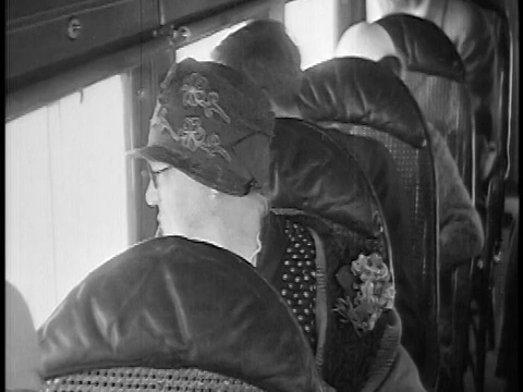 1927年近距离拍摄戴着帽子的资深女性坐在飞机上从窗户往外看/新闻短片视频素材