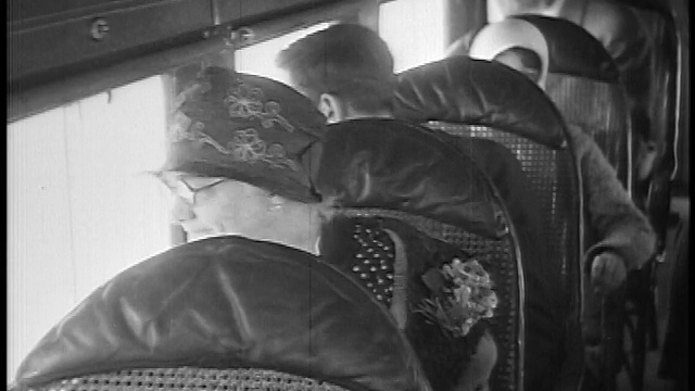 1927年近距离拍摄戴着帽子的资深女性坐在飞机上从窗户往外看/新闻短片视频素材
