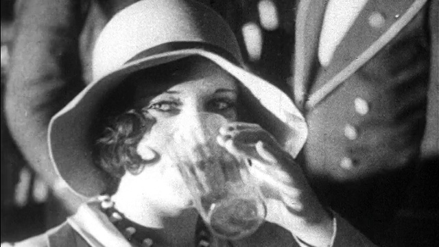 1928年B/W近距离拍手在帽子微笑+喝酒/新闻短片视频素材