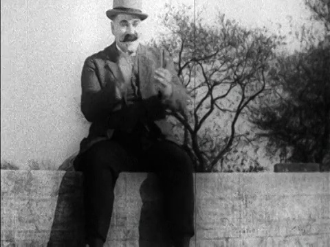 1925年左右，戴着帽子蓄着胡子的魁梧男子坐在马车上鼓掌视频素材
