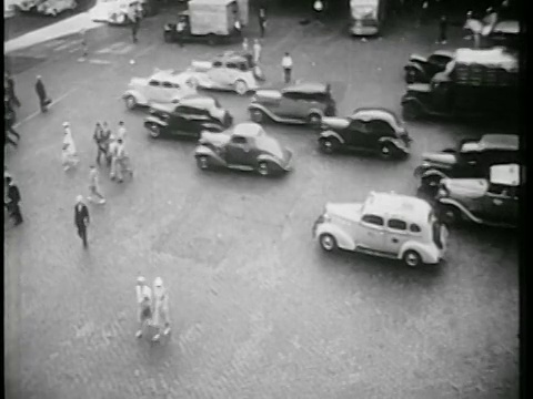 1939年的高角度交通+鹅卵石城市街道上的行人/纽约市/纪录片视频素材