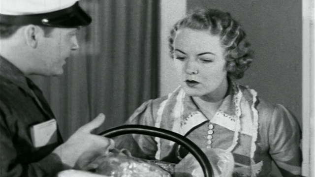 1938年的上门推销员向家庭主妇展示烘焙食品/工业产品篮子视频素材