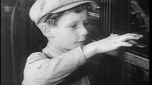 1934年，在Fon du Lac银行柜员窗口，一名戴着帽子的男孩在数硬币。视频下载