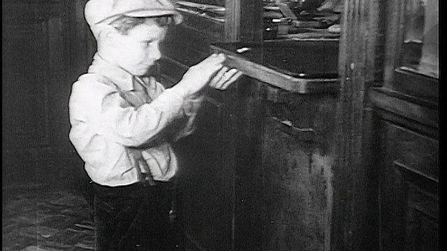 1934年，一名戴着帽子的男孩在Fon du Lac银行的出纳员窗口接受硬币/东皮奥里亚，IL视频下载