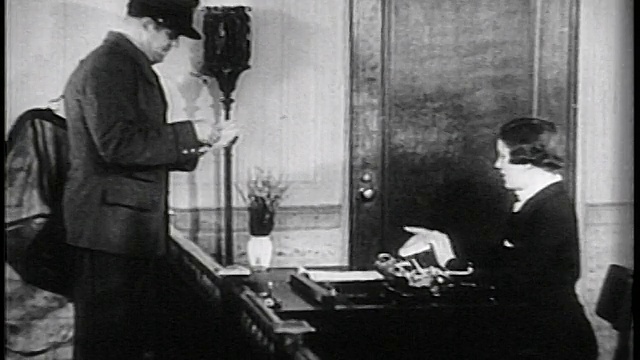 1936年B/W邮差与秘书在办公室/记录片台交换邮件视频素材