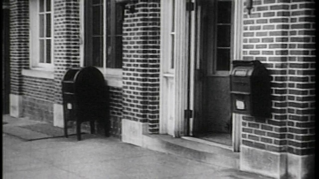 1936年，穿着工作服的黑人工人拿着饭盒进入邮局/纪录片视频素材