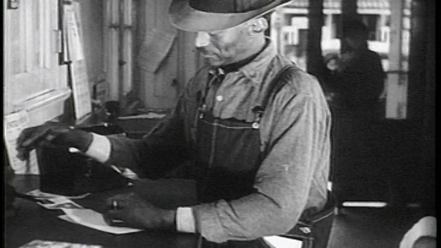 1936年，穿着工作服的黑人工人在邮局柜台写作/纪录片视频下载