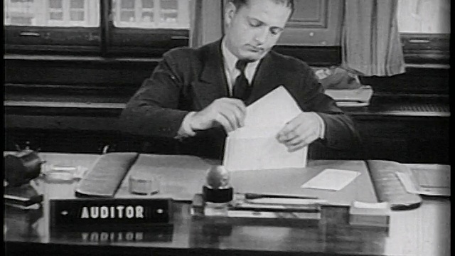1936年，商人在办公桌上写支票+放入信封/纪录片视频素材