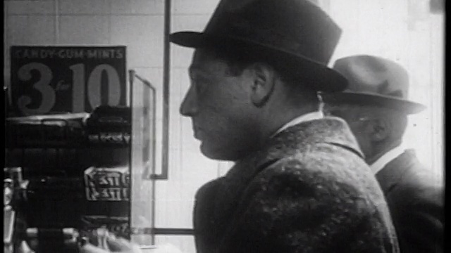 1939年戴着帽子在午餐柜台吃三明治的男人/纽约/纪录片视频素材