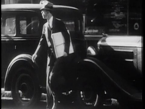 1939年，一名戴着帽子的男子爬过街道上停着的汽车/纽约/纪录片视频素材