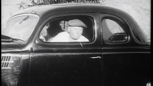 1939年戴着帽子的男子向车窗外吐痰/纪录片视频素材