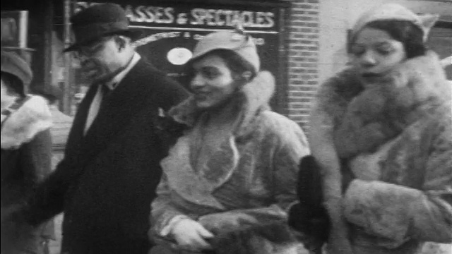 1930年PAN穿着皮草大衣和配套帽子的黑人妇女走在哈莱姆人行道上/纽约/新闻短片视频下载