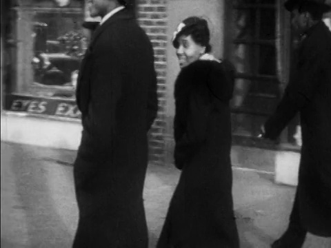 1930年，一对微笑的黑人夫妇走过哈莱姆人行道/纽约/新闻短片视频下载