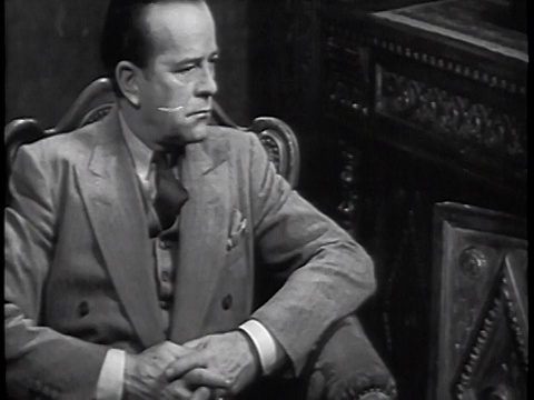 20世纪30年代穿着西装的男人坐着+听收音机/工业视频素材