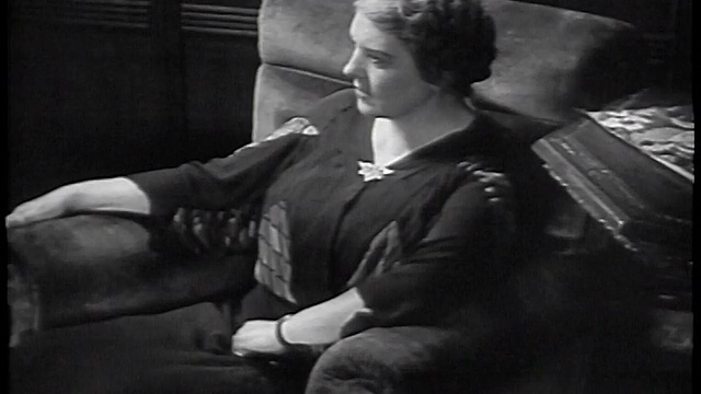 20世纪30年代的妇女坐在扶手椅上向前倾(听收音机)/工业视频素材