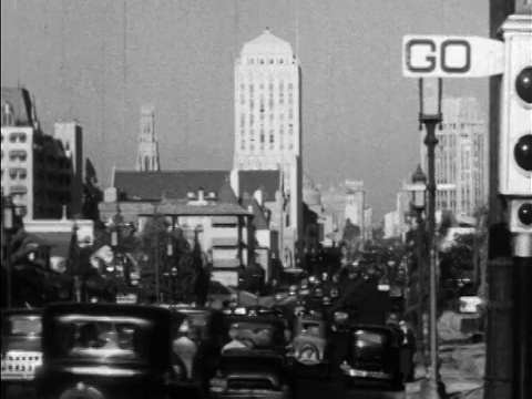1930在宽阔的城市街道上的后视图交通/背景中的建筑物/洛杉矶，CA视频下载