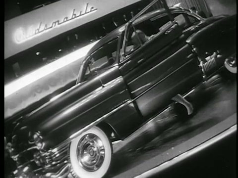 B/W 1945低角度倾斜的女人进入深色的汽车和关闭车门在汽车展厅/教育视频素材