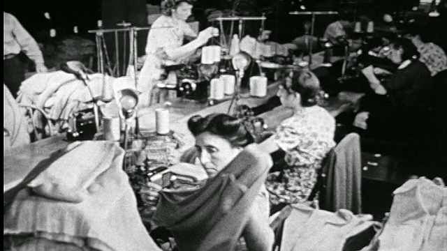 1946年B/W制衣厂线轴机器的工人处理毛衣视频素材