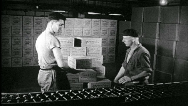 1946年B/W 2名男子从仓库的滚轴皮带上抢进箱/记录片视频素材