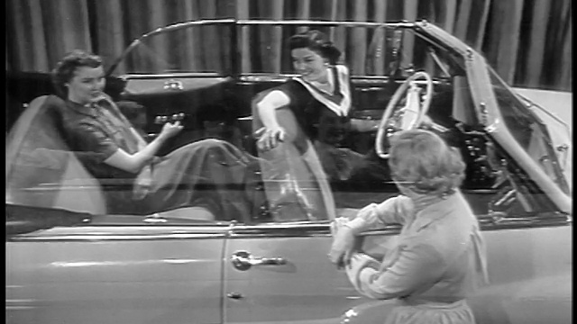黑色和白色1949高角度2妇女坐在水星敞篷车在展厅作为电动窗上升/工业。视频下载