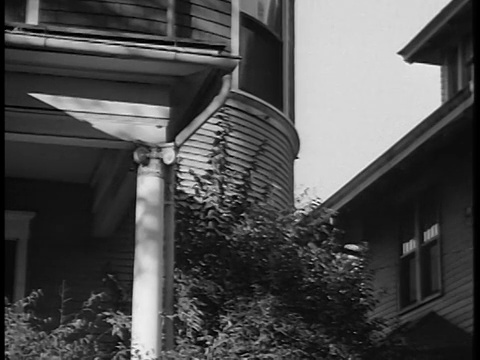 1944年，黑人和白人邮递员走过郊区的房子/纪录片视频素材