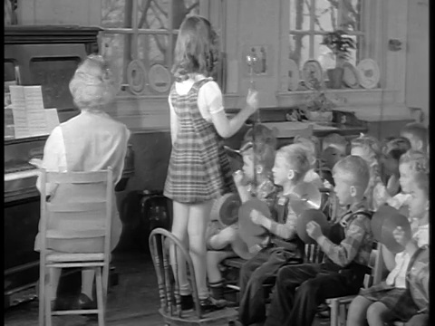 1944年，黑人和白人潘儿童演奏乐器，女孩指挥乐队，教师弹钢琴视频素材