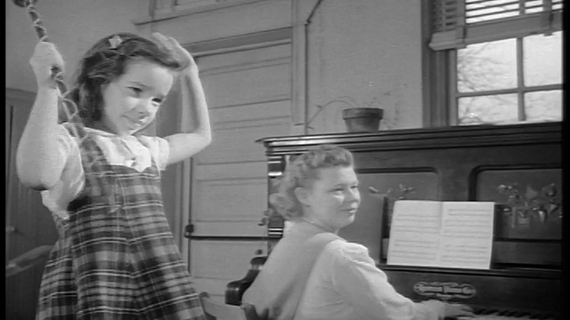 1944年，黑人和白人弹奏钢琴的妇女和年轻女孩用指挥棒指挥乐队/纪录片视频素材