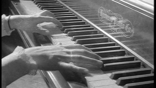 1944年的《黑与白》特写了一位弹奏钢琴的妇女的手/纪录片视频素材