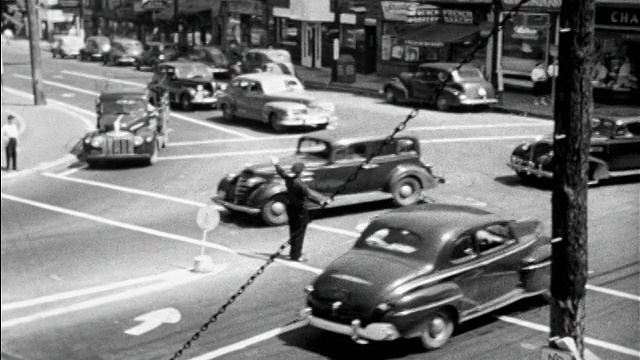 1948年，黑白高角度警察在十字路口拦下交通，让男孩可以过马路视频下载