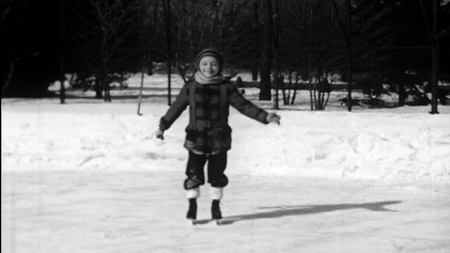 1948年男孩对着摄像机在池塘上滑冰/他摔倒了/指路视频下载