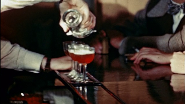 20世纪40年代的酒吧/旅行记录中，调酒师将饮料倒入玻璃器皿中视频素材