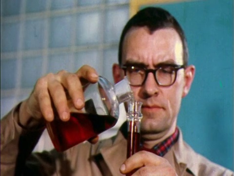 1957年，男科学家在眼镜中将红色液体从玻璃瓶倒入玻璃试管视频下载