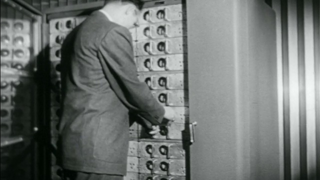 B/W 20世纪50年代后视图商人打开早期计算机记忆库门+拆卸组件视频素材