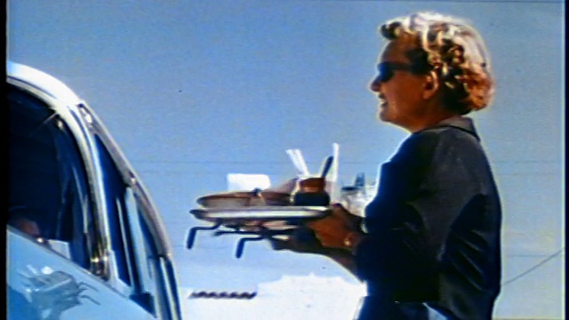 1958低角度服务员从车里拿走食物盘微笑+和车里的人说话/新闻短片视频素材