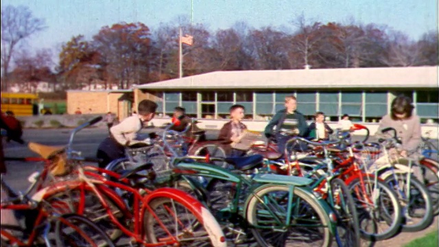 1957年，孩子们在教学楼外抢自行车+骑车离开/新泽西/工业视频素材