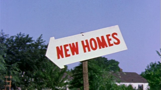 1959年，红色字母“新家园”的箭头形标识/蓝天+背景中的树木/费城/文档。视频素材