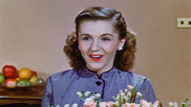 1952年的近景，兴奋的少女坐在花后与屏幕外的人交谈视频素材
