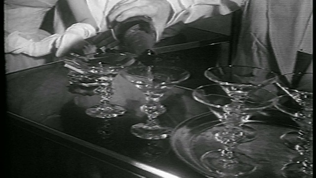1953年，酒吧/新闻短片上，酒保的手将香槟倒进玻璃杯视频素材