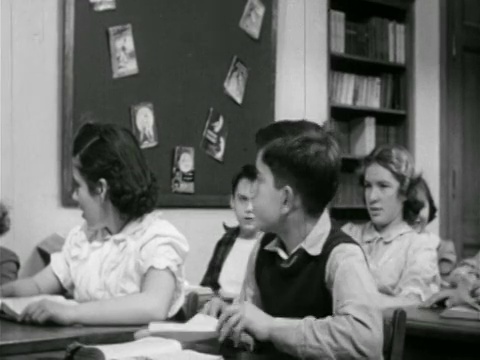1951年，男孩在课桌上站起来+准备在教室里扔纸飞机视频下载