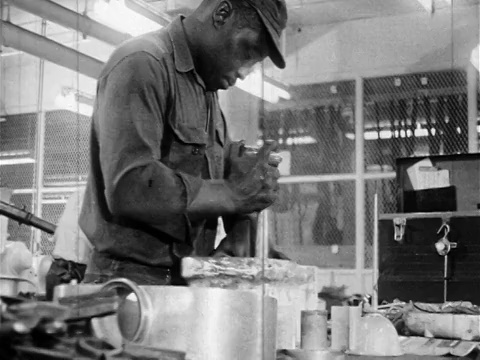 20世纪60年代黑色男性蓝领工人在室内桌子上使用工具/纪录片视频下载