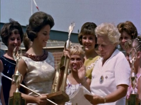 20世纪60年代的女人把奖杯送给乐队队长，其他人在看/洛杉矶/教育视频下载