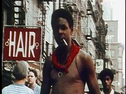 20世纪70年代的黑人脖子上戴着头巾，嘴里叼着笔走在纽约大街上/纪录片视频下载