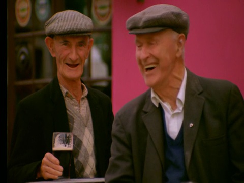 2个爱尔兰老人喝啤酒，微笑+大笑视频素材