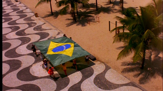 高角度的人们举着巨大的巴西国旗跑过头顶视频素材
