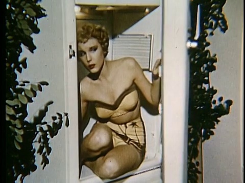 一个穿着泳衣的女人坐在冰箱里打开了门视频下载