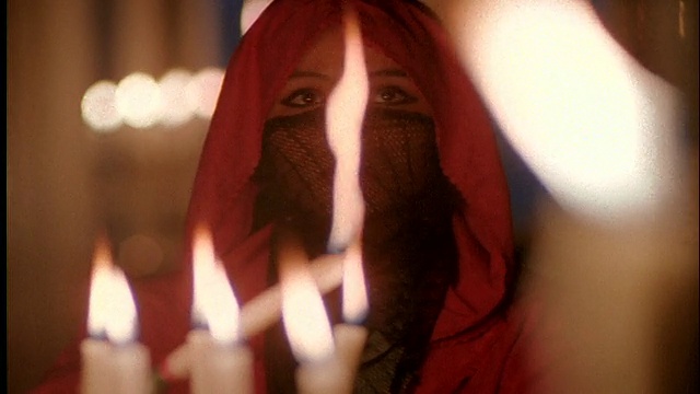 近距离拍摄蒙面的中东妇女点燃蜡烛/摩洛哥视频下载